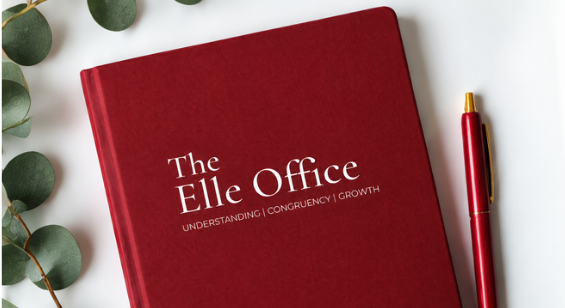 A red Elle Office notebook with a pen